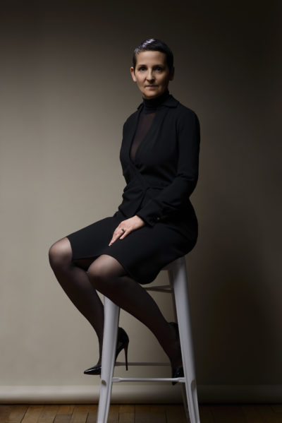 Claire D. en robe noire, collant résille et mules Ernest photographiée en studio par le photographe de boudoir - Paris