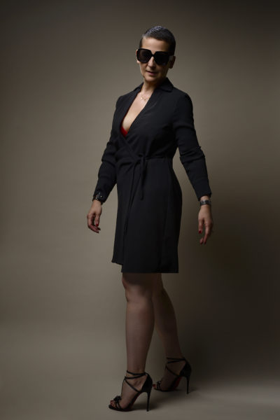 Claire D. en robe noire, chaussures Louboutin et lunettes noires, photographiée en studio par le photographe de boudoir - Paris